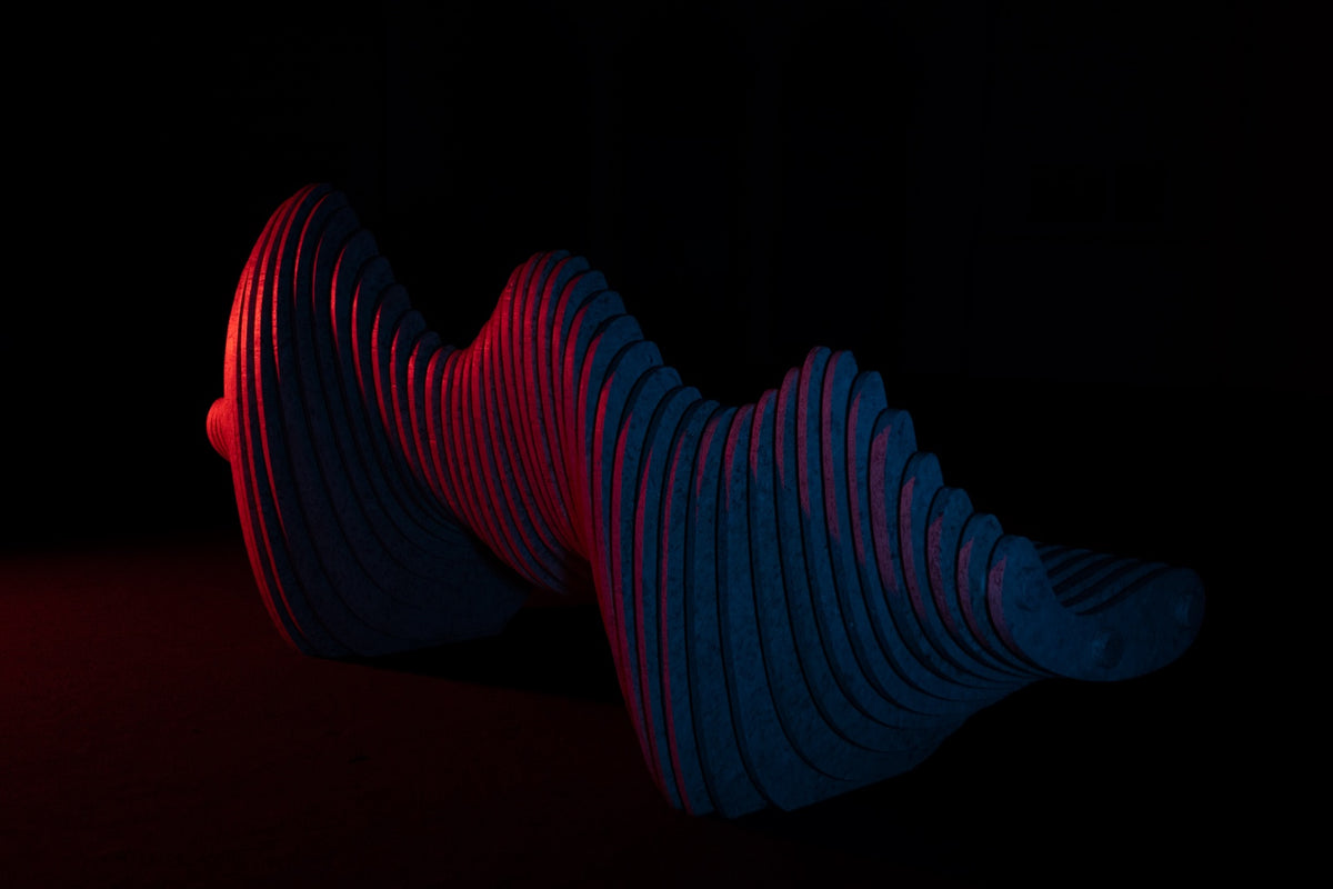 ITZAMNÁ, obra escultórica de NAWAL en plástico reciclado, iluminada en rojo y azul